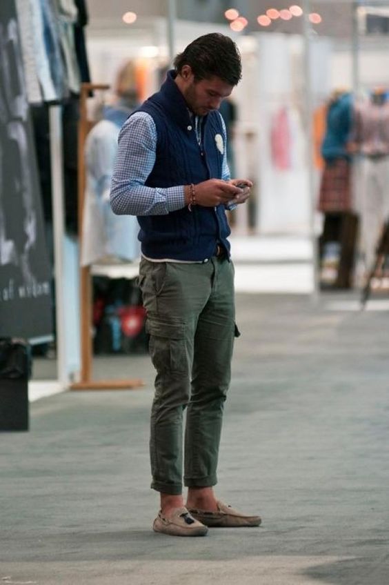 Blue checked shirt under navy quilted vest, green cargo pants